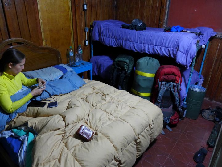 Refugio Cruz de Caña - перепаковка рюкзаков. Средний зелено-желтый мешок, весом 30 кг, поедет на муле