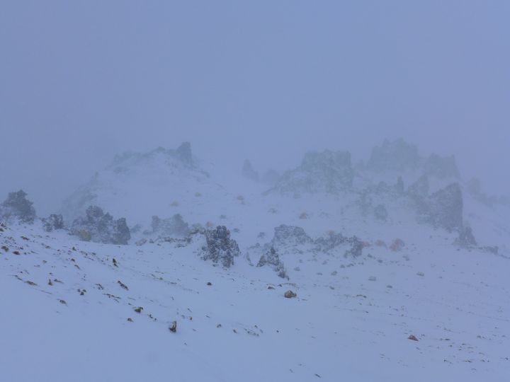 В снежном тумане внизу впереди палатки лагеря Колера